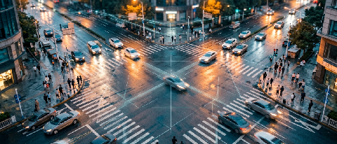 Aerial view of a modern city intersection with flowing traffic and subtle digital connectivity lines