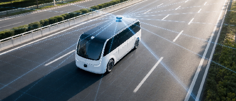A conceptual editorial image showing a sleek autonomous vehicle driving on a modern highway, with a subtle overlay of laser grid lines representing LiDAR scanni