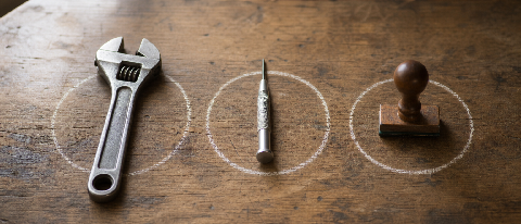 Three different workshop tools arranged on a wooden bench, each representing a different workflow approach.