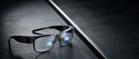 A pair of futuristic AI glasses on a concrete surface with a sharp dividing line symbolizing a barrier.