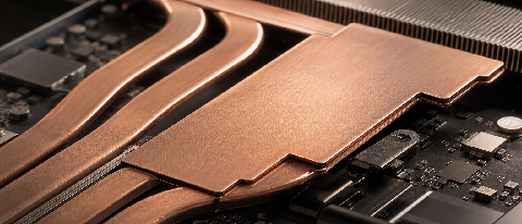 Close-up of a vapor chamber and heat pipes on a laptop motherboard with metallic textures and soft lighting.