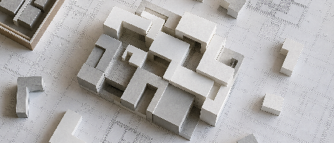 A conceptual editorial image showing modular geometric blocks assembling into a cohesive structure on a technical blueprint background, symbolizing the engineer