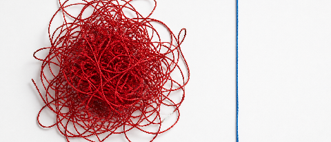 A complex, tangled knot of red strings on a clean desk, contrasting with a simple straight line nearby, symbolizing the unnecessary complexity of Graph RAG.