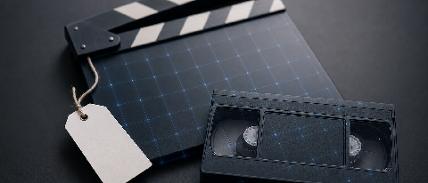 Editorial still life of a film clapperboard and video cassette on a desk, overlaid with a translucent digital watermark grid and a blank compliance label tag, s