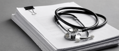 A close-up of a medical contract with a stethoscope resting on it, symbolizing the need for clear liability agreements in AI healthcare.