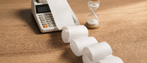 A long, complex receipt curling out of a calculator on a desk, symbolizing opaque token billing.