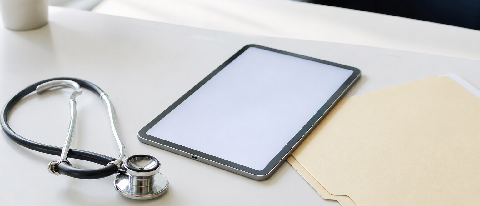A professional doctor's desk with a stethoscope and a tablet, symbolizing AI-assisted diagnosis.
