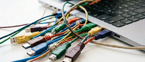 A tangled knot of colorful cables on a desk, symbolizing failed data integration and complex workflows