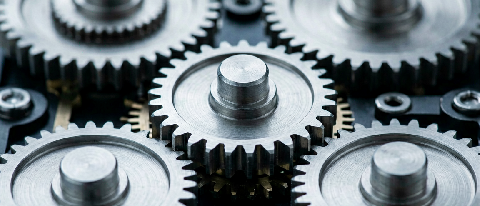 A conceptual editorial image showing a complex mechanical gear system with one specific gear highlighted, representing the bottleneck in a larger machine.