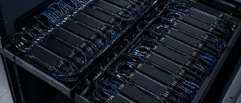 Server rack densely packed with interconnected AI accelerator chips and cables in a data center
