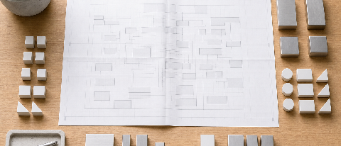 A neatly organized desk with a blueprint and sorted components representing code refactoring