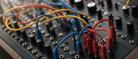 A macro shot of colorful patch cables connecting modules on a professional synthesizer, symbolizing a technical workflow.