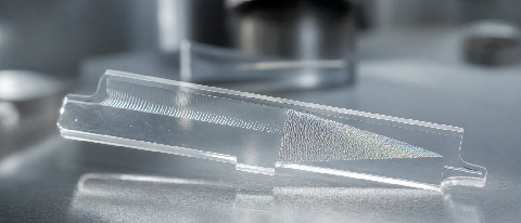 A detailed macro view of an optical waveguide component in a cleanroom setting.