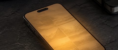 A sleek smartphone resting on a dark surface, emitting a soft, contained glow that illuminates abstract photographic elements inside its screen, while the backg
