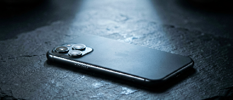 A sleek smartphone resting on a dark surface with soft, contained lighting representing local processing