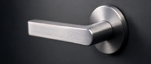 A sleek, minimalist door handle on a matte black surface representing controlled access